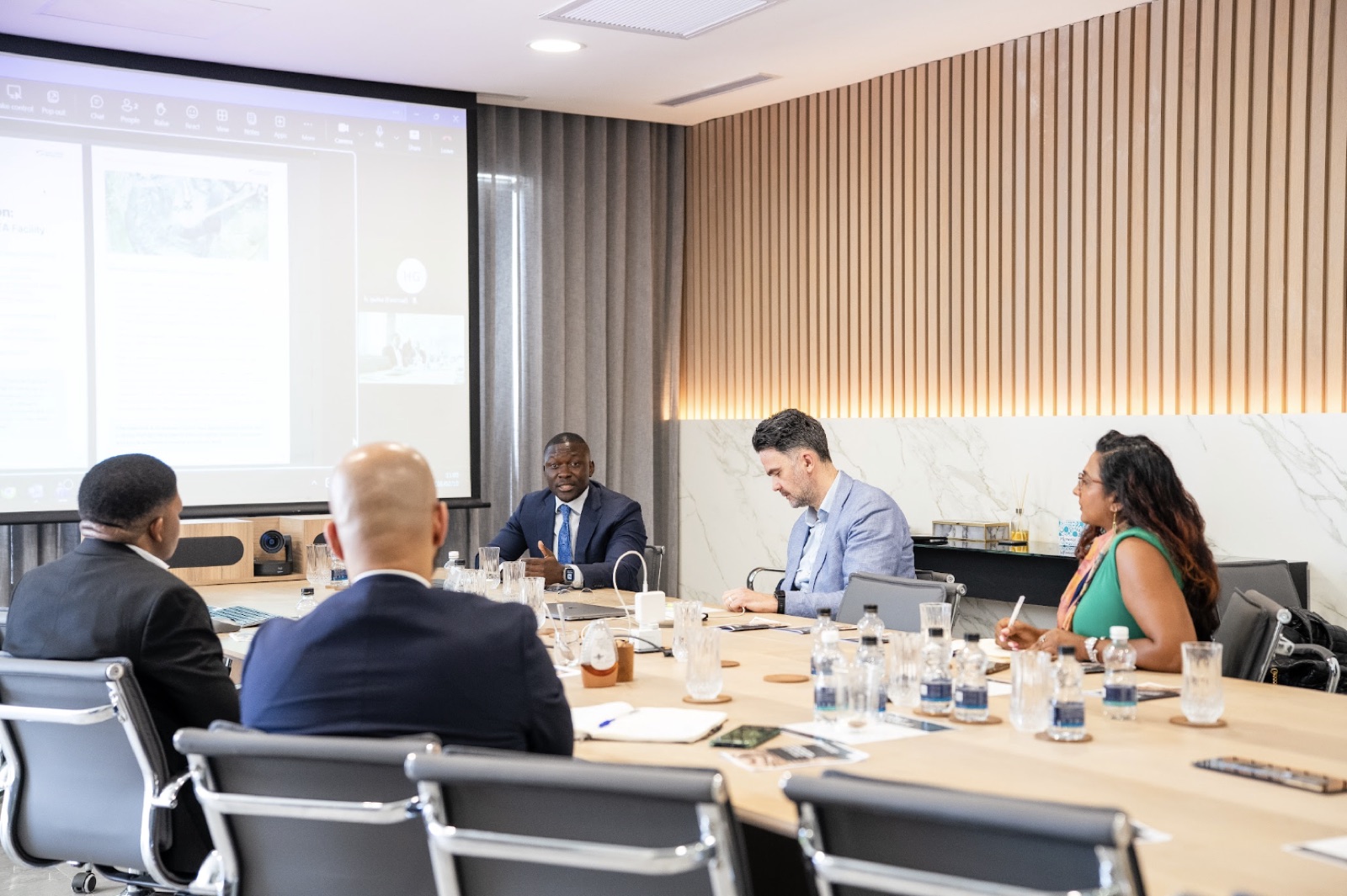 Investment team in a boardroom meeting reviewing a project presentation